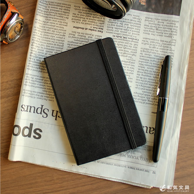<b>世界中で愛されているノート「モレスキン」</b>撥水加工された黒く硬い表紙と手帳を閉じるためのゴムバンド。