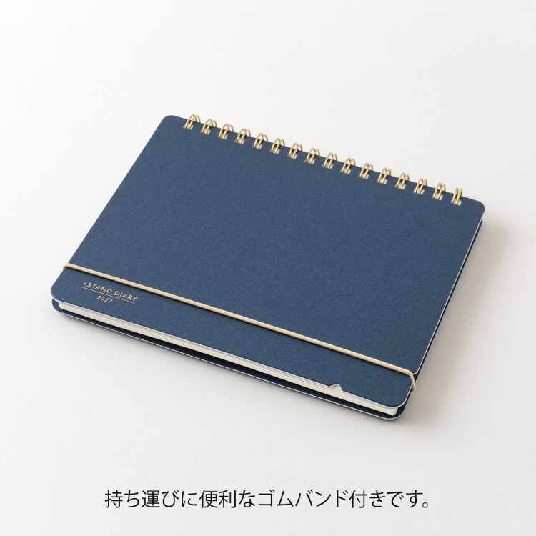ページを開いて、ゴムバンドを表紙の切り込みに引っかけるだけで卓上カレンダーのように簡単に立てることができます。